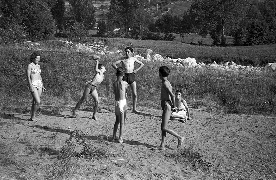 38_FAM_5786_30: Grup de nens, amb banyador, jugant a tirar pedres a l’alçada de les Dos Valires