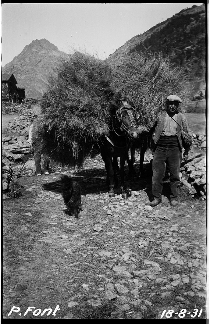 FEDA_0406: Un home vestit amb pantalons de pana, armilla, gorra i sarró de vímet
